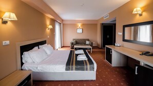 A hotel room with a bed, a desk, a chair, and a sofa. - Hotel Oxford Inns & Suites (Timisoara)