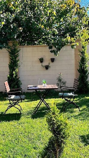 A patio with a table, two chairs, and a laptop. - Hotel Oxford Inns & Suites (Timisoara)