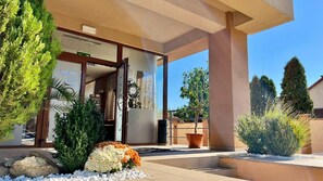 A hotel entrance with a covered patio, a reception desk, and a view of the surrounding landscape. - Hotel Oxford Inns & Suites (Timisoara)