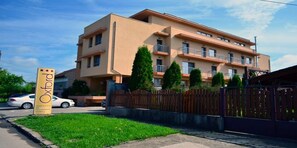 A multi-story building with a beige facade, a sign with stars, and a gated entrance. - Hotel Oxford Inns & Suites (Timisoara)