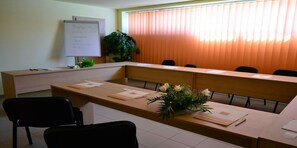 A conference room with a long table, chairs, a whiteboard, and a plant. - Hotel Oxford Inns & Suites (Timisoara)