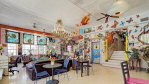 A spacious room with a chandelier, a ceiling fan, and a staircase with a railing.