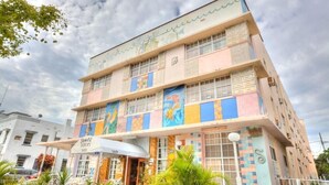 A multi-story hotel with colorful exterior murals and a visible sign for "James Holez".