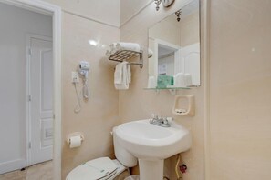 A bathroom with a white sink, a towel rack, a hairdryer, and a mirror. - James Hotel (Miami Beach)