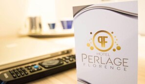Une chambre d’hôtel avec une télécommande posée sur la table.