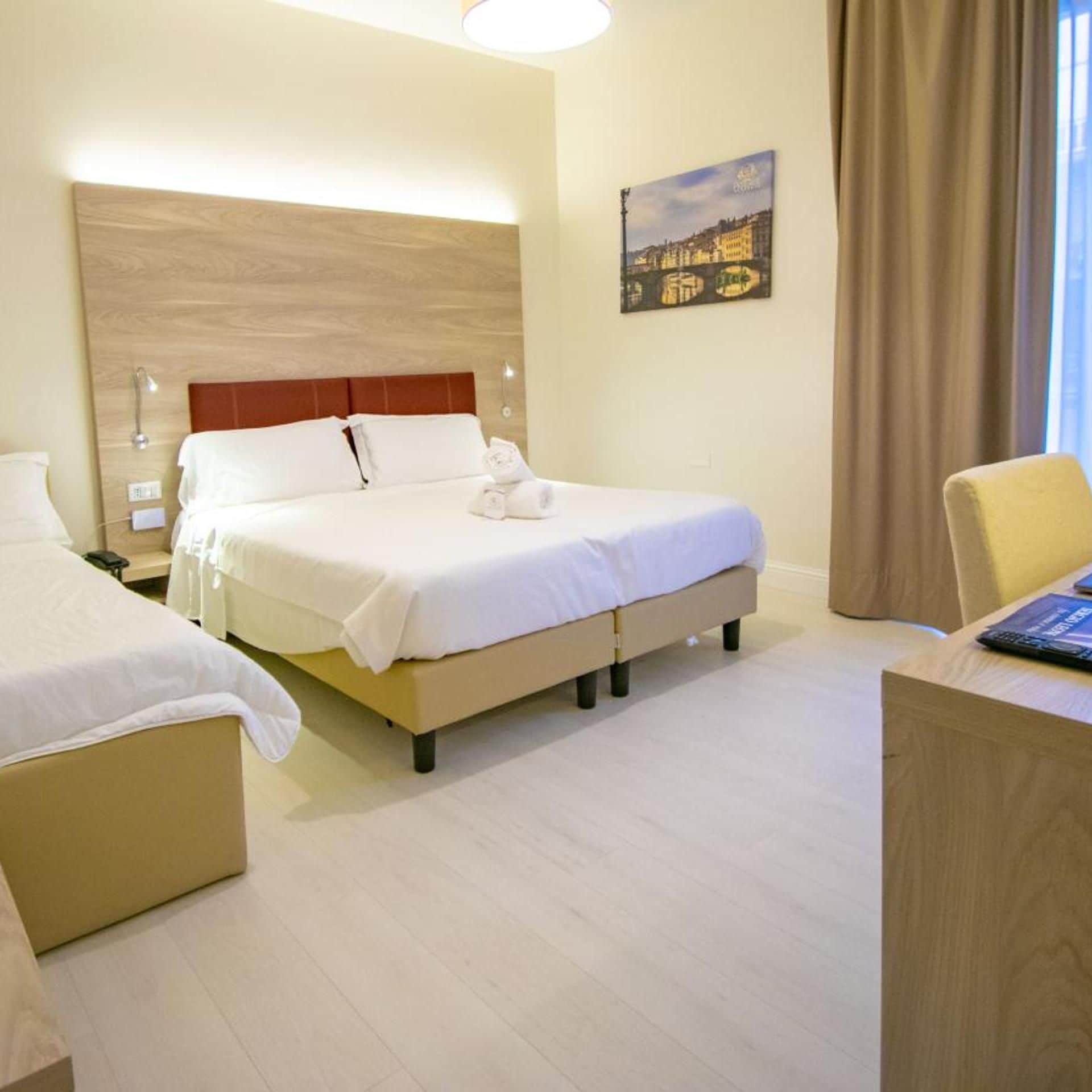 A hotel room with a bed, a desk, and a chair.