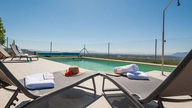 A poolside area with lounge chairs, towels, and a hat. - Antigua Casa Rufo Pozo Alcón by Ruralidays (Jaén)