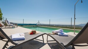 A poolside area with lounge chairs, towels, and a hat. - Antigua Casa Rufo Pozo Alcón by Ruralidays (Jaén)