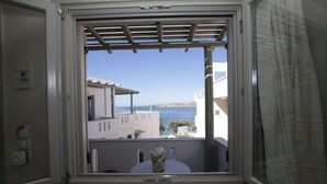 A balcony with a view of the sea and buildings.
