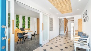 A modern interior with a reception desk, seating area, and a staircase. - Marianna Hotel (Santorini)