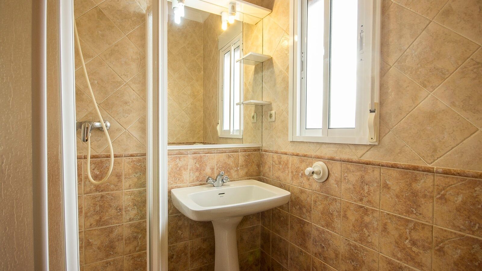 Un bagno con lavandino, specchio e doccia.