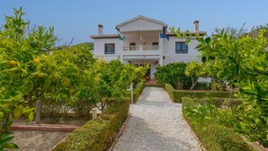 A two-story house with a balcony, surrounded by well-maintained gardens and a gravel pathway. - Casa Rural Parador del Silo Cónchar by Ruralidays (Granada)