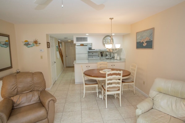 Relax in this open-plan living space with a dining table, sofa, and armchair.