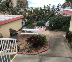 Enjoy a tranquil outdoor space with a picnic table, benches, and lush garden.