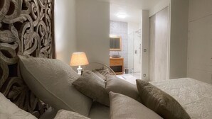 Une chambre d’hôtel avec un lit, des oreillers, une lampe et une tête de lit décorative.