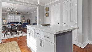 Una cocina moderna con armarios blancos, una isla central e iluminación colgante.
