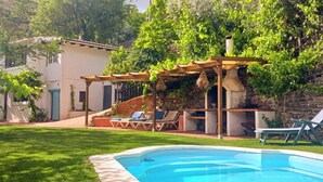 A backyard with a swimming pool, a pergola, and lounge chairs. - Almez De Lúa Güéjar Sierra by Ruralidays (Granada)