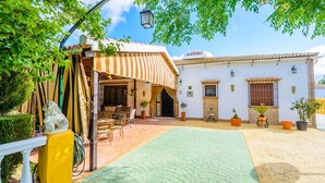 A courtyard with a covered seating area, a statue, and potted plants. - La Torna Carcabuey by Ruralidays (Córdoba)