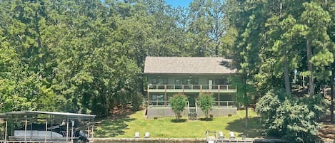 A lodge with a dock, surrounded by dense forest.