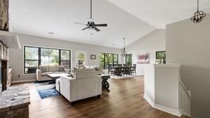 A spacious living room with a fireplace, a dining area, and a kitchen.