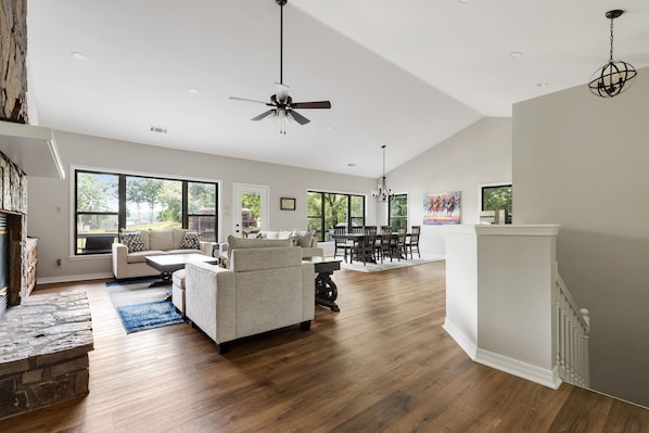 A spacious living room with a fireplace, a dining area, and a kitchen.