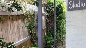 A narrow pathway leading to a building labeled "Studio." - Jones Beach Haven Studio Escape Kiama Downs opposite patrolled beach and park (KIAMA DOWNS)