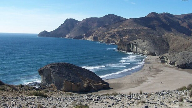 A coastal landscape with a rocky beach, cliffs, and a large boulder in the foreground. - Casas María Carmona - Casa Tierra Níjar by Ruralidays (Almería)