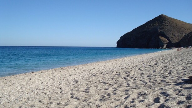 A beach with a rocky cliff and clear blue water. - Casas María Carmona - Casa Luna Níjar by Ruralidays (Almería)