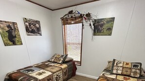 A room with two beds, a window with a view, and wall art.