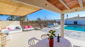 Relax by the pool with a refreshing drink in hand, surrounded by comfortable seating and a serene view.