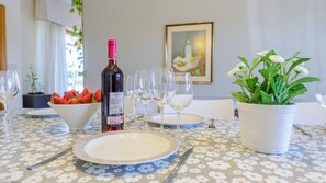 Enjoy a casual meal at this inviting dining table, set with fine china, wine, and fresh fruit.