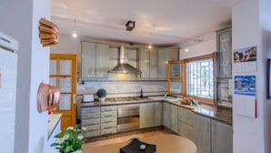 Una cocina moderna con encimeras de granito, electrodomésticos de acero inoxidable y un amplio ventanal que proporciona luz natural.