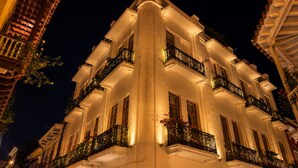 Un edificio de varios pisos con balcones, ventanas amplias y un estilo arquitectónico clásico.