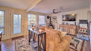 A cozy living room with a fireplace, a television, and a large window. - < 1 Mi to Beech Mtn Ski! Condo w/ Hot Tub Access (Beech Mountain)