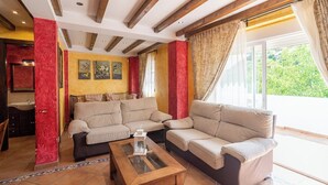 Ein Wohnzimmer mit zwei beigefarbenen Sofas, einem Glastisch und einer roten Akzentwand.