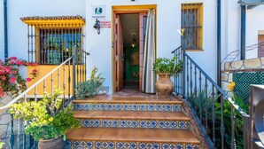 Una escalera con baldosas de diseño azul y blanco que lleva a una puerta de madera.