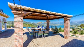 Une terrasse extérieure avec une table et des chaises, une piscine et une vue sur les montagnes.