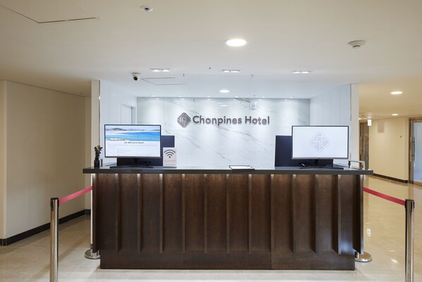 A reception desk at the Chin Pines Hotel with a marble wall and two monitors. - Sokcho Chonpines Beach Hotel (Sokcho)