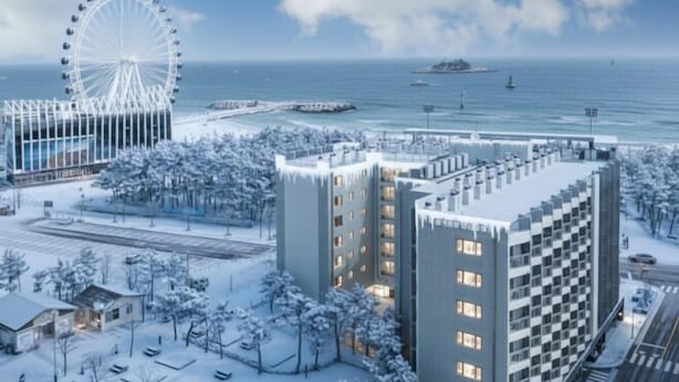 Et moderne hotel med en central gårdsplads, et pariserhjul og udsigt til havet.