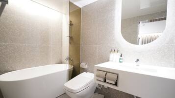 A modern bathroom with a bathtub, toilet, and sink.
