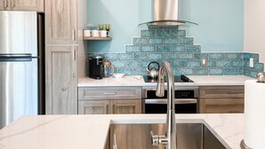 A modern kitchen with wooden cabinets, a stainless steel refrigerator, a coffee maker, and a kettle on the counter. - Main Street Loft/Luxury 2nd Floor 1100 sq ft Condo (Cottonwood)