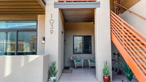 A modern building entrance with a staircase, potted plants, and outdoor seating. - Main Street Loft/Luxury 2nd Floor 1100 sq ft Condo (Cottonwood)