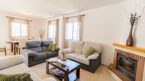 A living room with two sofas, a coffee table, and a fireplace. - Villa Jazmín Viñuela by Ruralidays (Málaga)