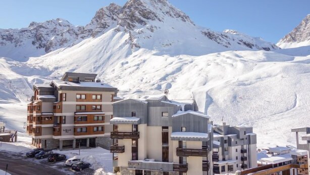 A modern ski resort with multi-story buildings, a parking area, and a mountain backdrop. - Le Prariond (Val Claret) by Interhome (Tignes)