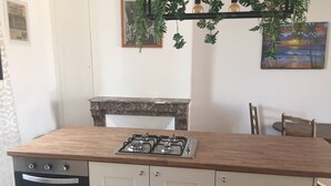 A kitchen with a wooden countertop, gas stove, oven, and cabinets. - 2 Bed-Roof Terrace-Town Centre-Pets (Montmorillon)