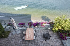 A patio with a table and chairs, a bench, and potted plants.