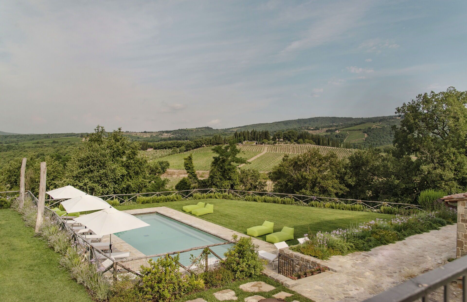 A pool area with a view of rolling hills and vineyards.