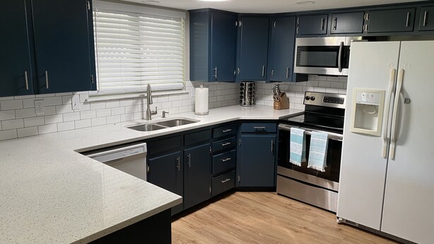A modern kitchen with dark blue cabinets, a stainless steel refrigerator, a microwave, and a dishwasher. - Perfect for Long Stays. Recently remodeled townhouse next to Freeway & C of I.  (Caldwell)