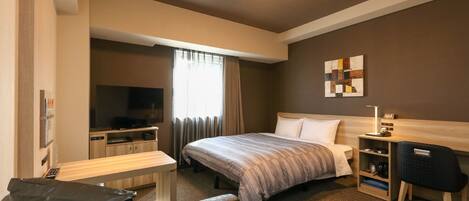 A hotel room with a bed, a desk, a chair, a television, and a window with curtains.