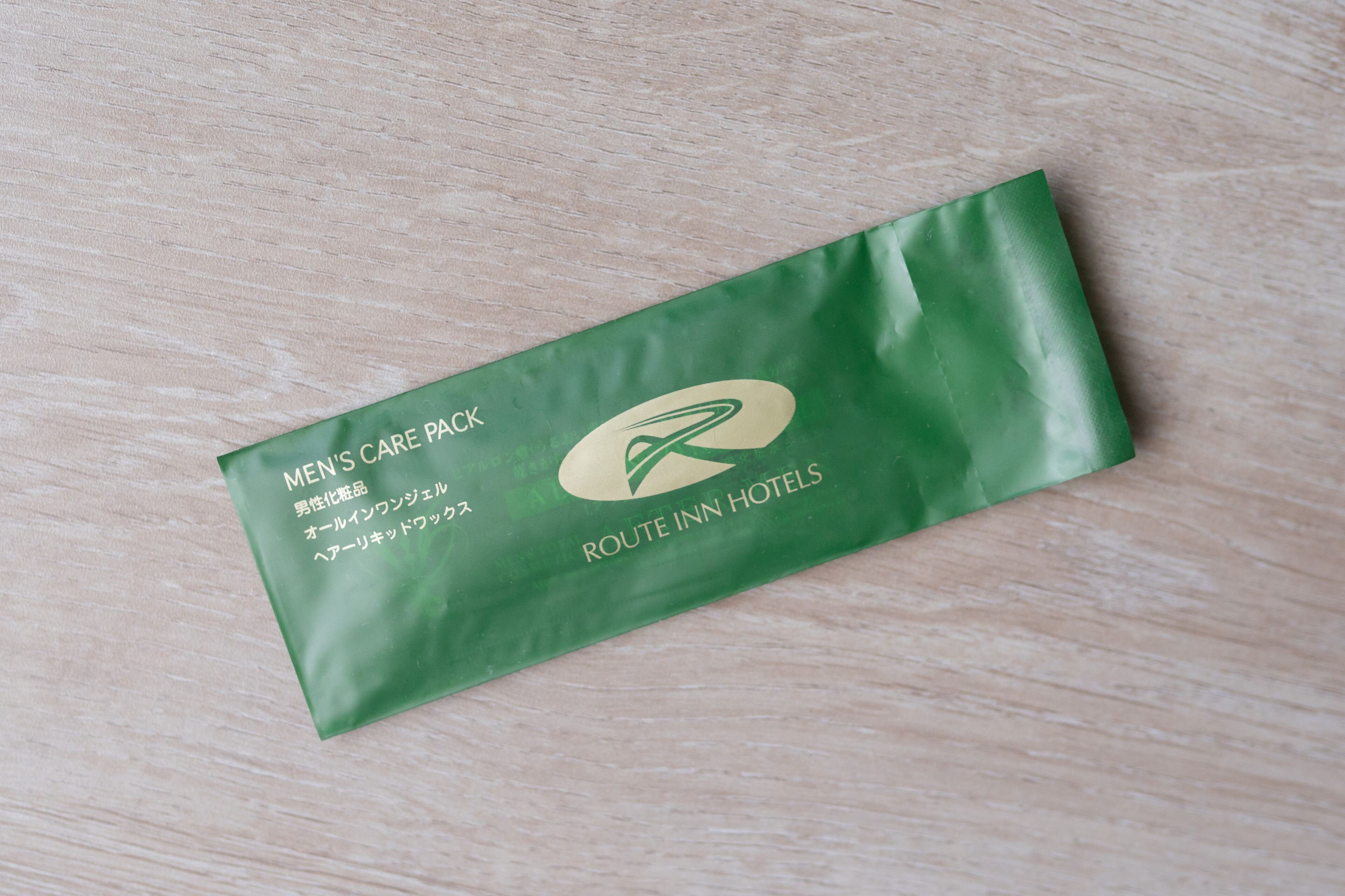 A green men's care pack from Route Inn Hotels.